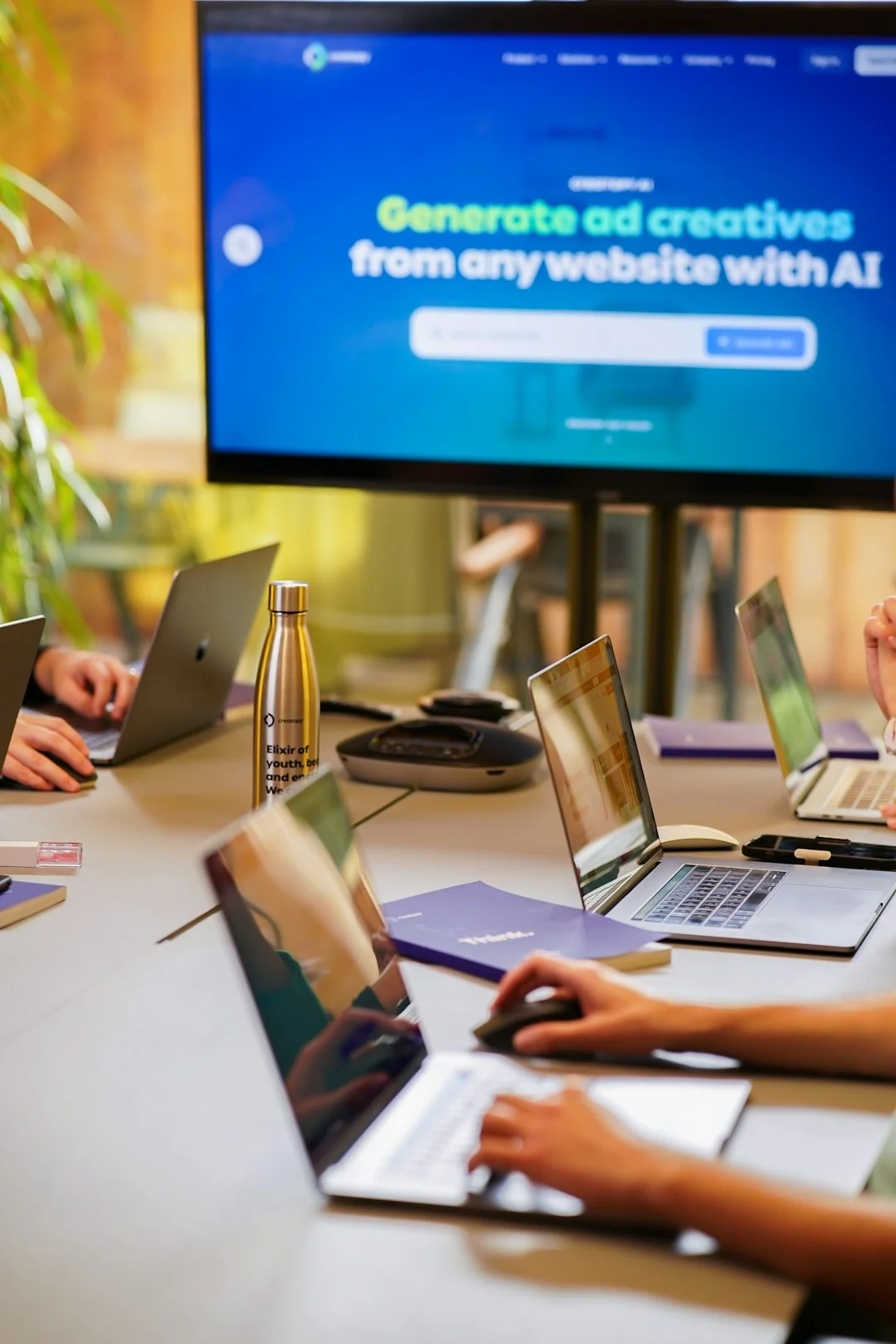 Un espace de travail moderne où des mains analysent des données marketing sur un ordinateur portable et des documents papier.